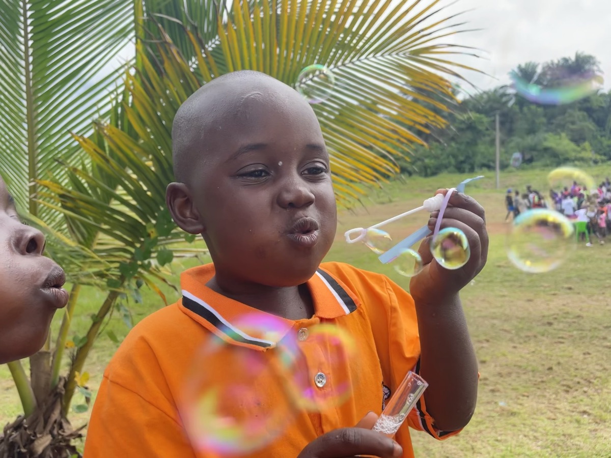 A boy blowing bubbles at a Psalm 82:3 Mission gathering in Liberia